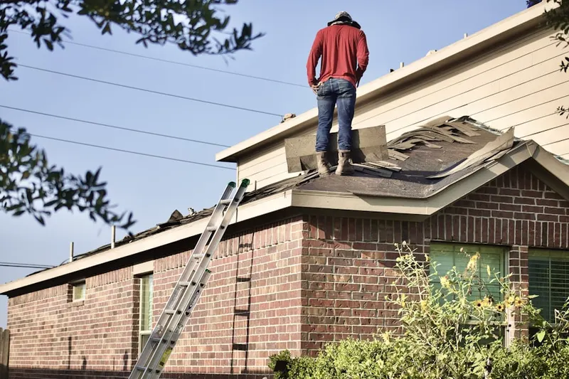 Professional roofer working on a residential roof in Howland Corners